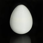 White 3D-printed dino egg standing closed on a black background