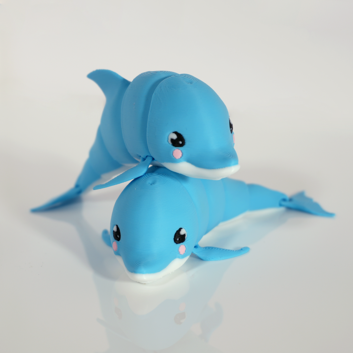 Two blue kawaii dolphin 3D prints stacked on each other