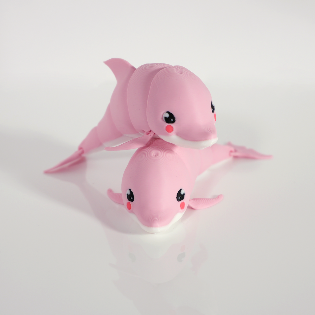 Pair of pink articulated dolphins, one resting on the other