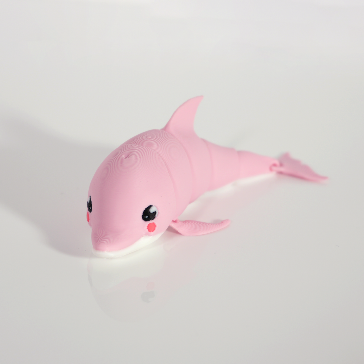 Pink articulated kawaii dolphin 3D print with a white belly and rosy cheeks