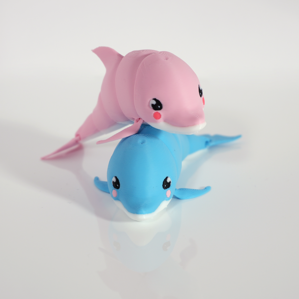 Cutie Pies set: a pink dolphin resting on a blue dolphin