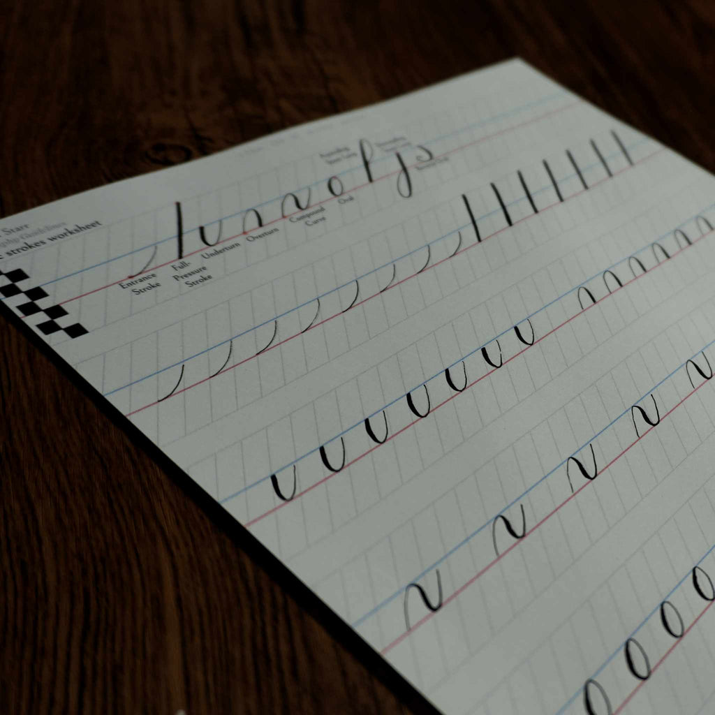 Printed calligraphy worksheet with pointed-pen practice strokes on guidelines