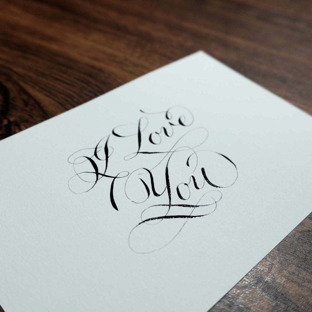 Close-up of "I Love You" in pointed-pen copperplate calligraphy with flourishes