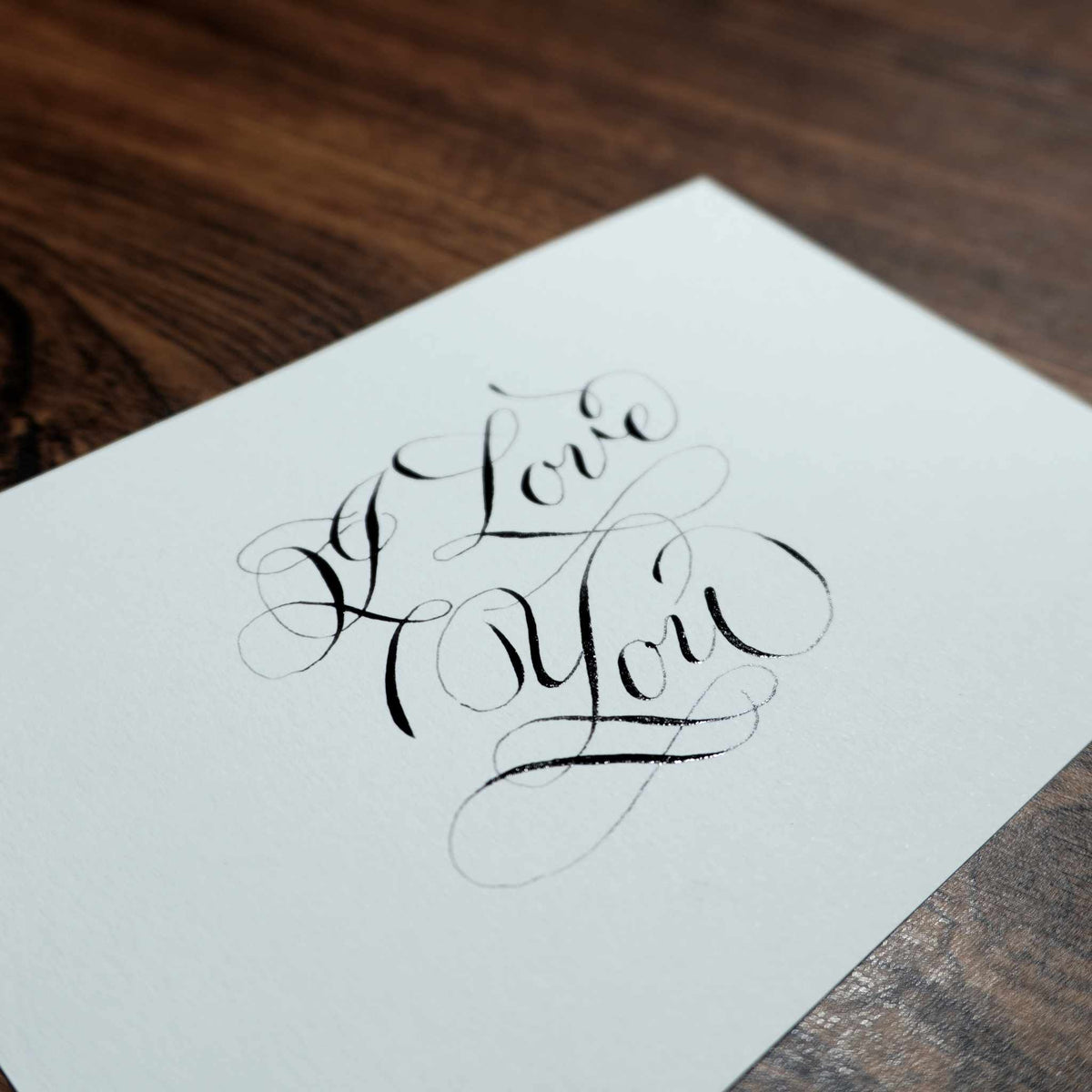 Close-up of "I Love You" in pointed-pen copperplate calligraphy with flourishes