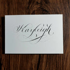 The name "Kayleigh" hand-lettered in copperplate calligraphy on a white card